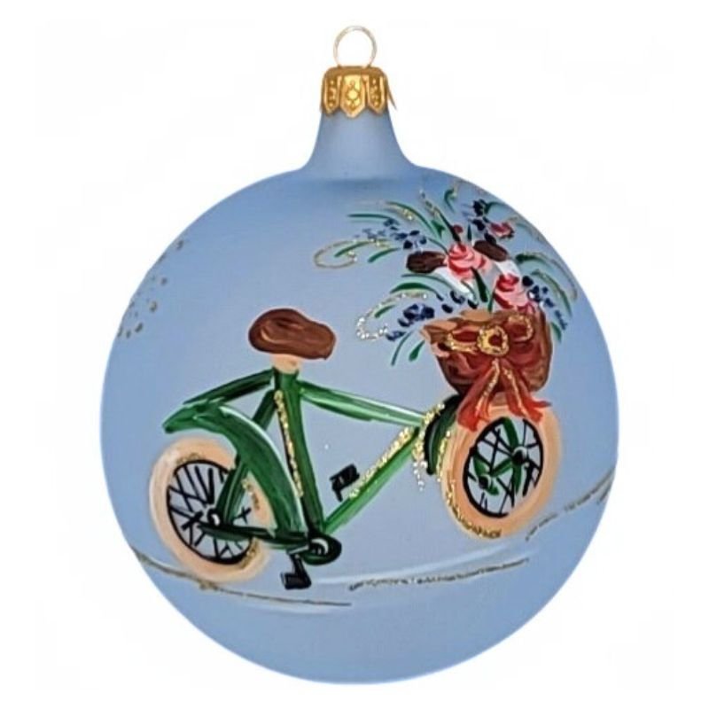 Round  blown glass ornament in matte pale blue with a green bike with a basket full of flowers hand painted on it