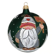 Round blown glass ornament in matte green with a gnome holding a noel sign hand painted on it