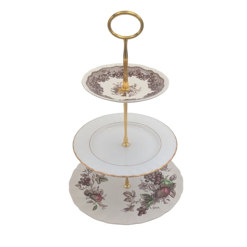 Three vintage china plates used to create a 3-tier serving stand with floral and gold detailing, handcrafted for elegant entertaining and home decor.