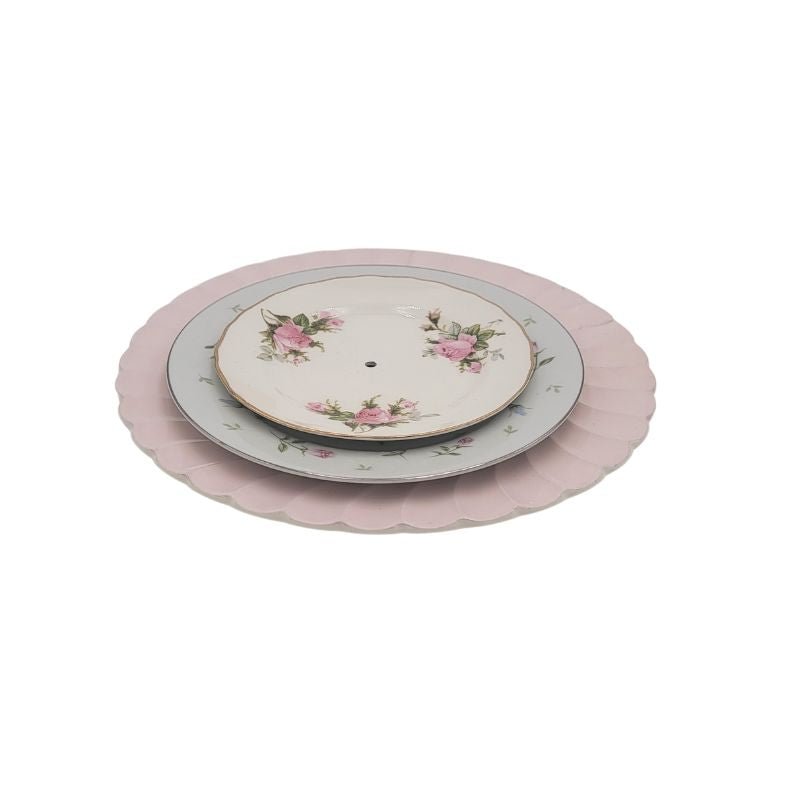 Stack of three vintage plates in pink floral patterns.