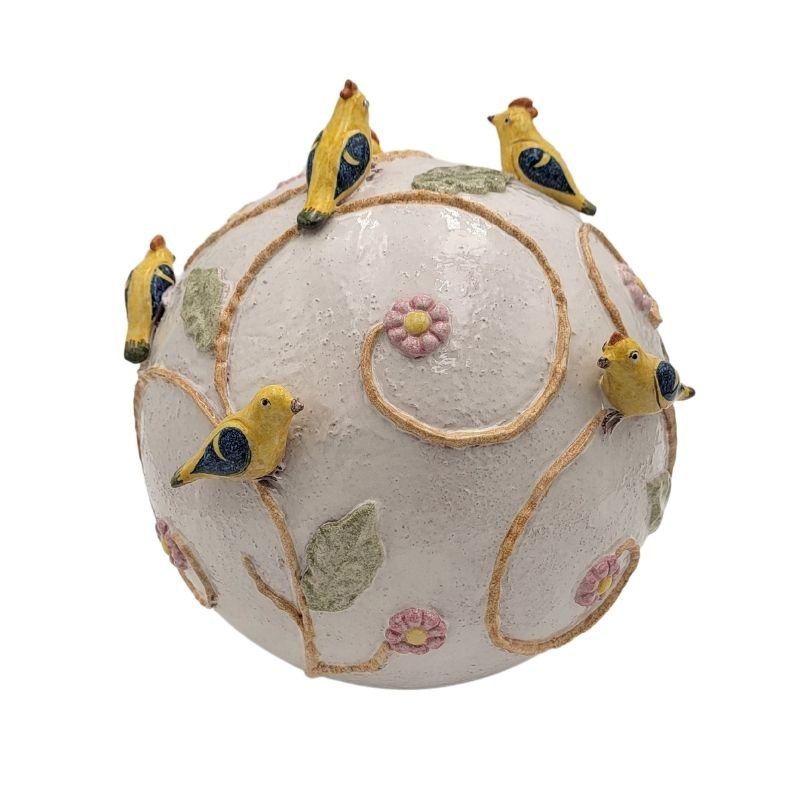 Large ceramic sphere with raised birds and flowers.