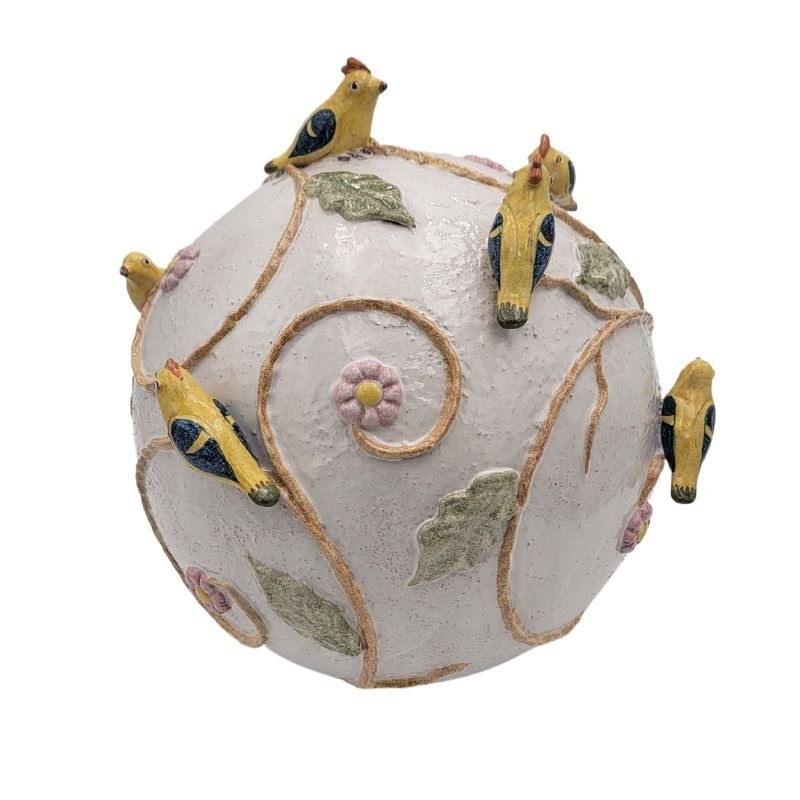 Large ceramic sphere with raised birds and flowers.