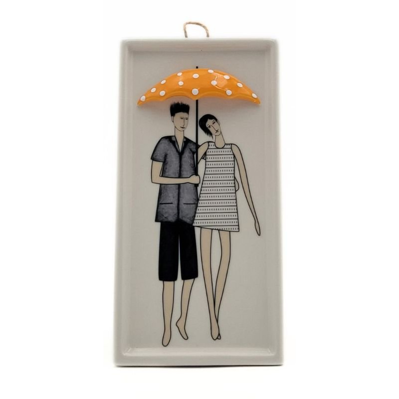 Ceramic white rectangular plaque with a couple painted on it with a three dimensional yellow polka dot umbrella