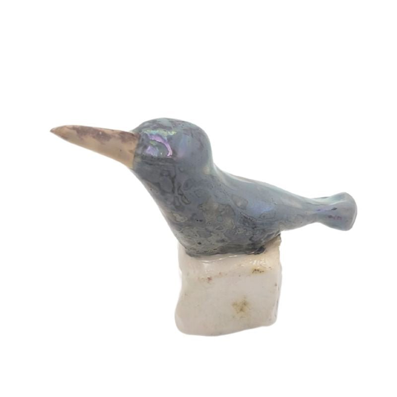 Ceramic hummingbird figurine painted in a blue grey color with an iridescent glaze.