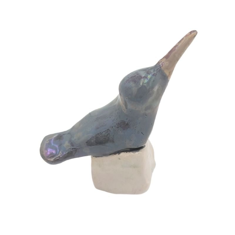 Ceramic hummingbird figurine painted in a blue grey color with an iridescent glaze.