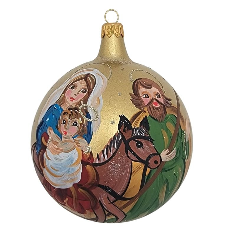 Blown glass ball ornament in matte gold with Mary, Joseph and baby Jesus on a donkey hand painted on it