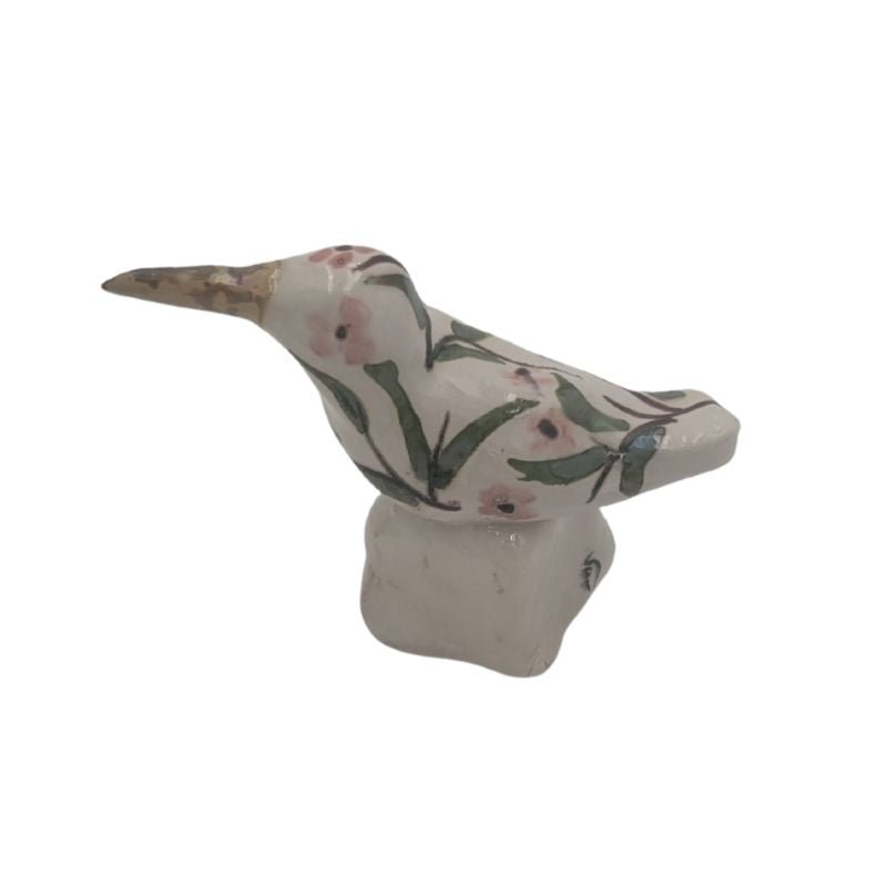 Handcrafted hummingbird figurine with soft pink floral pattern and iridescent glaze, one-of-a-kind art piece for bookshelf or tabletop display.