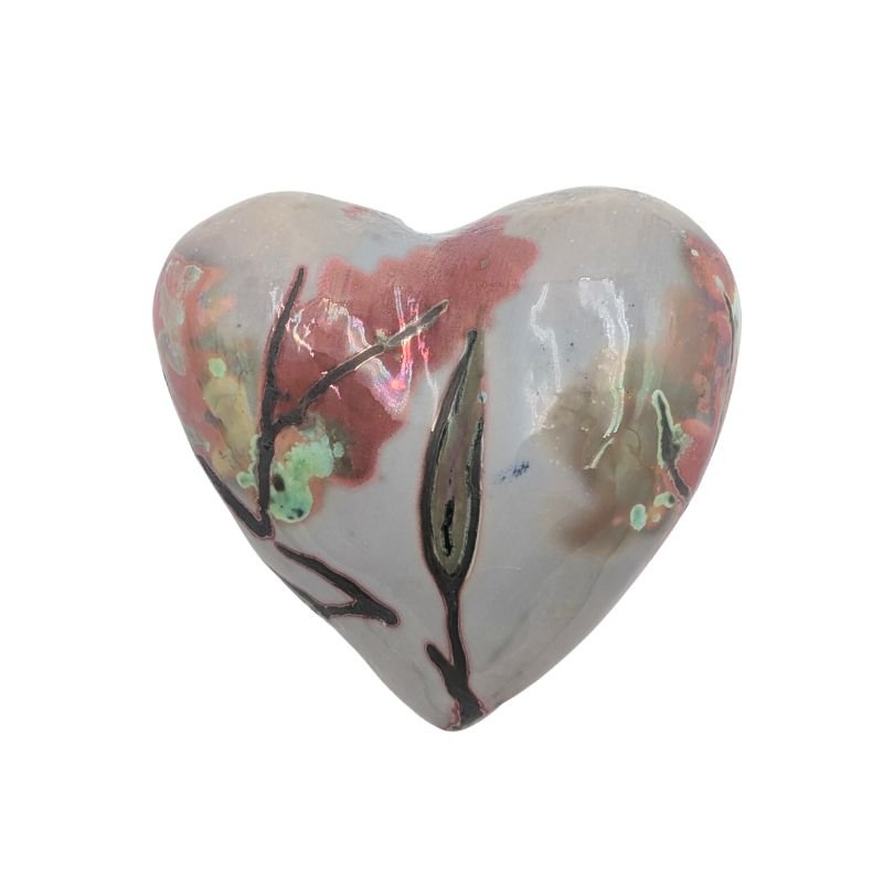 Handcrafted ceramic heart with soft coral floral pattern and iridescent glaze detailing.