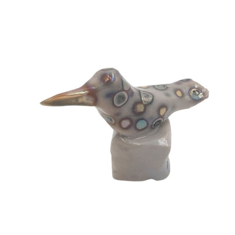 Hand painted hummingbird figurine with an iridescent dog pattern.